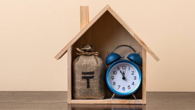 Kazakistan 'da sembolik ahşap bir ev ve içinde Kazak para birimi sembolü olan bir para çantası olan gayrimenkul konulu kavramsal bir komplo.