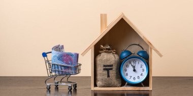 Kazakistan 'da sembolik ahşap bir ev ve içinde Kazak para birimi sembolü olan bir para çantası olan gayrimenkul konulu kavramsal bir komplo.