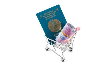 Kazakistan Cumhuriyeti vatandaşının pasaportu ve minyatür bir alışveriş arabasında 10.000 tenge banknot.