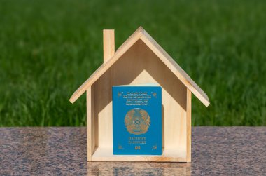 Kazakistan Cumhuriyeti vatandaşının pasaportu ve minyatür bir ahşap ev.