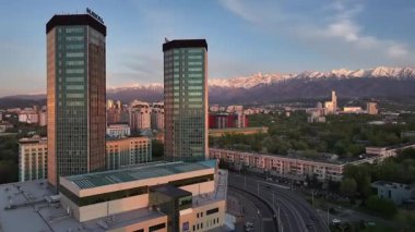 Almaty, Kazakistan, 04.20.2025. Bir bahar akşamı Kazak şehri Almaty 'nin merkezindeki yüksek katlı binalara ait bir kuadkopter görüntüsü.