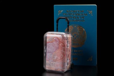 Minyatür bir seyahat çantasının içindeki 5,000 tenge banknot ve Kazakistan Cumhuriyeti vatandaşının pasaportu.