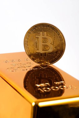 Üzerinde kripto para sembolü olan altın sikke ve beyaz zemin üzerinde altın külçe