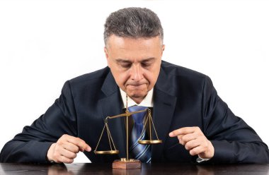 Orta yaşlı, takım elbiseli, altın pullu bir adam.