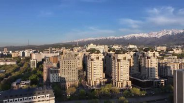 Almaty, Kazakistan, 04.20.2025. Bir bahar akşamı Kazak şehri Almaty 'nin merkezindeki yüksek katlı binalara ait bir kuadkopter görüntüsü.
