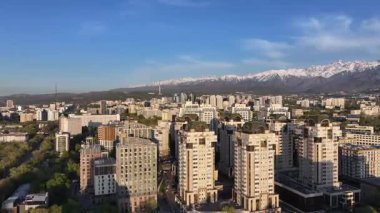 Almaty, Kazakistan, 04.20.2025. Bir bahar akşamı Kazak şehri Almaty 'nin merkezindeki yüksek katlı binalara ait bir kuadkopter görüntüsü.