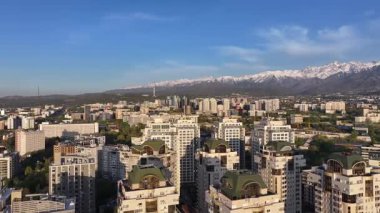 Almaty, Kazakistan, 04.20.2025. Bir bahar akşamı Kazak şehri Almaty 'nin merkezindeki yüksek katlı binalara ait bir kuadkopter görüntüsü.