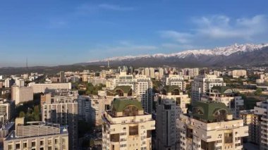 Almaty, Kazakistan, 04.20.2025. Bir bahar akşamı Kazak şehri Almaty 'nin merkezindeki yüksek katlı binalara ait bir kuadkopter görüntüsü.