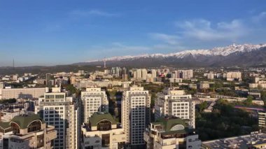 Almaty, Kazakistan, 04.20.2025. Bir bahar akşamı Kazak şehri Almaty 'nin merkezindeki yüksek katlı binalara ait bir kuadkopter görüntüsü.