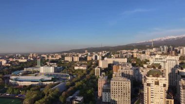 Almaty, Kazakistan, 04.20.2025. Bir bahar akşamı Kazak şehri Almaty 'nin merkezindeki yüksek katlı binalara ait bir kuadkopter görüntüsü.