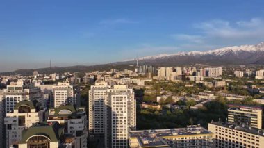 Almaty, Kazakistan, 04.20.2025. Bir bahar akşamı Kazak şehri Almaty 'nin merkezindeki yüksek katlı binalara ait bir kuadkopter görüntüsü.