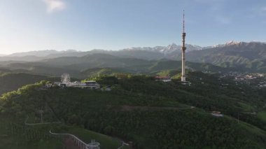 Kok Tobe Dağı (Mavi Tepe) ve ünlü TV kulesi Kazak şehri Almaty 'deki Zailiyskiy Alatau dağ sırasının arka planına karşı bir bahar sabahı erken saatlerde
