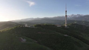 Kok Tobe Dağı (Mavi Tepe) ve ünlü TV kulesi Kazak şehri Almaty 'deki Zailiyskiy Alatau dağ sırasının arka planına karşı bir bahar sabahı erken saatlerde