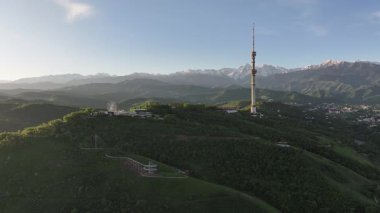 Kok Tobe Dağı (Mavi Tepe) ve ünlü TV kulesi Kazak şehri Almaty 'deki Zailiyskiy Alatau dağ sırasının arka planına karşı bir bahar sabahı erken saatlerde