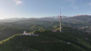 Kok Tobe Dağı (Mavi Tepe) ve ünlü TV kulesi Kazak şehri Almaty 'deki Zailiyskiy Alatau dağ sırasının arka planına karşı bir bahar sabahı erken saatlerde