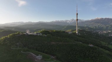 Kok Tobe Dağı (Mavi Tepe) ve ünlü TV kulesi Kazak şehri Almaty 'deki Zailiyskiy Alatau dağ sırasının arka planına karşı bir bahar sabahı erken saatlerde