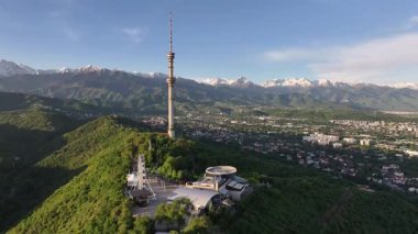 Kok Tobe Dağı (Mavi Tepe) ve ünlü TV kulesi Kazak şehri Almaty 'deki Zailiyskiy Alatau dağ sırasının arka planına karşı bir bahar sabahı erken saatlerde