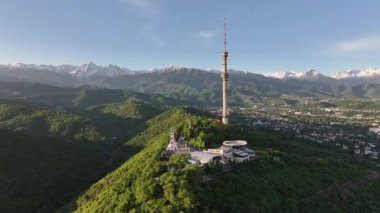 Kok Tobe Dağı (Mavi Tepe) ve ünlü TV kulesi Kazak şehri Almaty 'deki Zailiyskiy Alatau dağ sırasının arka planına karşı bir bahar sabahı erken saatlerde