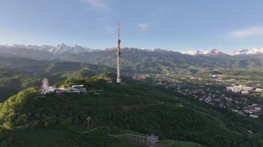 Kok Tobe Dağı (Mavi Tepe) ve ünlü TV kulesi Kazak şehri Almaty 'deki Zailiyskiy Alatau dağ sırasının arka planına karşı bir bahar sabahı erken saatlerde