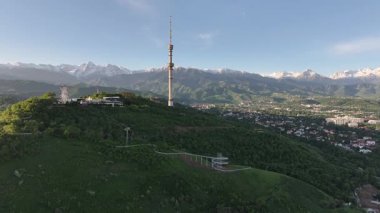 Kok Tobe Dağı (Mavi Tepe) ve ünlü TV kulesi Kazak şehri Almaty 'deki Zailiyskiy Alatau dağ sırasının arka planına karşı bir bahar sabahı erken saatlerde