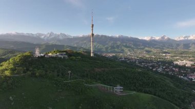 Kok Tobe Dağı (Mavi Tepe) ve ünlü TV kulesi Kazak şehri Almaty 'deki Zailiyskiy Alatau dağ sırasının arka planına karşı bir bahar sabahı erken saatlerde