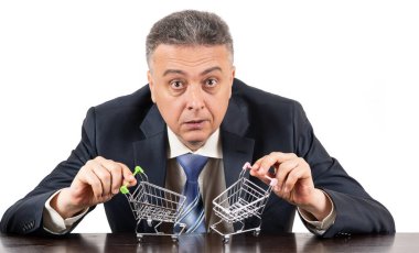 Takım elbiseli orta yaşlı bir adam ve iki boş süpermarket arabası.