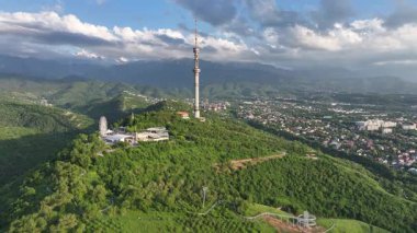 Kok Tobe Dağı (Mavi Tepe) ve ünlü TV kulesi Kazak şehri Almaty 'deki Zailiyskiy Alatau dağ sırasının arka planına karşı bir bahar akşamı