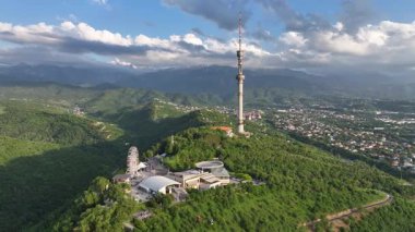 Kok Tobe Dağı (Mavi Tepe) ve ünlü TV kulesi Kazak şehri Almaty 'deki Zailiyskiy Alatau dağ sırasının arka planına karşı bir bahar akşamı
