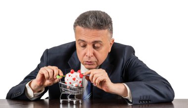 Orta yaşlı takım elbiseli bir adam ve süpermarketten minyatür alışveriş arabasında kumbaralı bir adam.