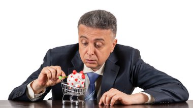 Orta yaşlı takım elbiseli bir adam ve süpermarketten minyatür alışveriş arabasında kumbaralı bir adam.