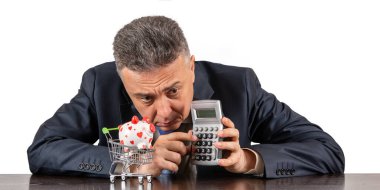 Orta yaşlı takım elbiseli bir adam ve süpermarketten minyatür alışveriş arabasında kumbaralı bir adam.