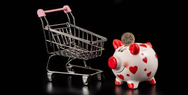 İçinde 1 İngiliz poundu ve boş bir süpermarket arabası olan bir kumbara.