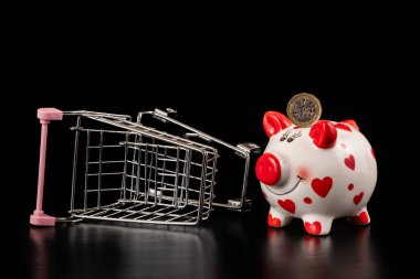 İçinde 1 İngiliz poundu ve boş bir süpermarket arabası olan bir kumbara.