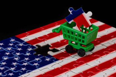 Amerikan bayrağının yapbozu ve süpermarketten alınmış minyatür bir alışveriş arabası.