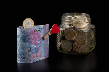 10,000 Kazakistanlı banknot ve siyah arkaplanda insan kalbi resmi olan bir mandal.