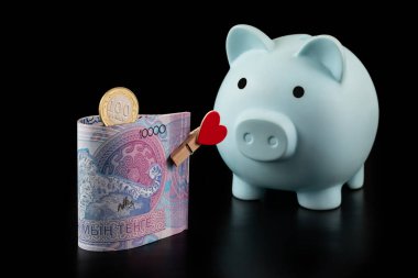 10,000 Kazakistanlı banknot ve siyah arkaplanda insan kalbi resmi olan bir mandal.