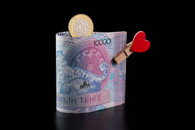 10,000 Kazakistanlı banknot ve siyah arkaplanda insan kalbi resmi olan bir mandal.
