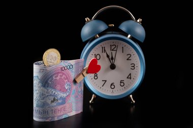 10,000 Kazakistanlı banknot ve siyah arkaplanda insan kalbi resmi olan bir mandal.