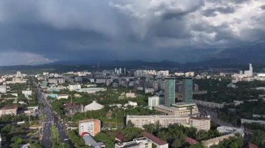 Kazak şehri Almaty 'nin merkez kısmının bir kuadkopterinden ve Zailiyskiy Alatau dağları üzerindeki gök gürültülü bulutlardan görüntüyü izleyin.