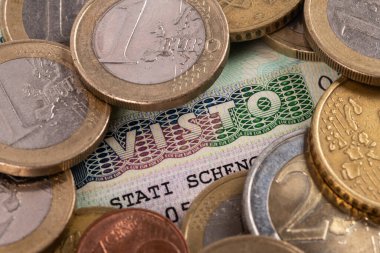 Italian Schengen visa and EURO coins of various denominations
