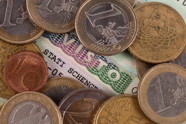 Italian Schengen visa and EURO coins of various denominations