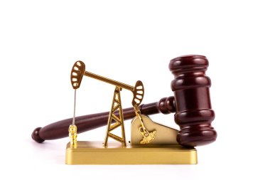 Golden miniature oil pump and hammer judge on white background