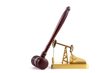 Golden miniature oil pump and hammer judge on white background