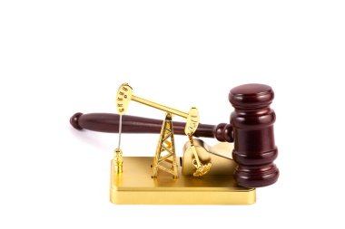 Golden miniature oil pump and hammer judge on white background