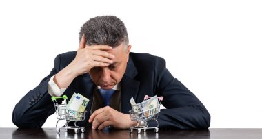 Orta yaşlı, takım elbiseli ve mini market arabalı 100 Euro ve 100 $'lık banknotlarla.