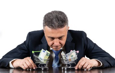 Orta yaşlı, takım elbiseli ve mini market arabalı 100 Euro ve 100 $'lık banknotlarla.