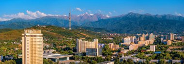 Kazak şehri Almaty 'nin orta kesiminin bir kuadkopterinden bir yaz akşamında Zailiysky Alatau dağlarının arka planına bakın.