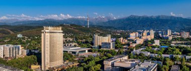 Kazak şehri Almaty 'nin orta kesiminin bir kuadkopterinden bir yaz akşamında Zailiysky Alatau dağlarının arka planına bakın.