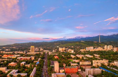 Kazak şehri Almaty 'nin orta kesiminin bir kuadkopterinden bir yaz akşamında Zailiysky Alatau dağlarının arka planına bakın.