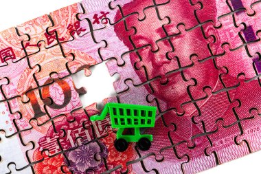 100 yuan 'lık bir yapboz parçası ve minyatür süpermarket alışveriş arabası.